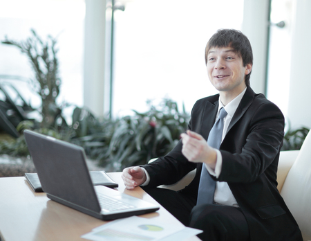businessman talking to colleague sitting at his Deskの写真素材