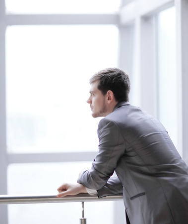 Businessman standing near the window and looking into itの写真素材