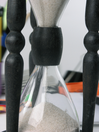 close up.hourglass on blurred background of office supplies