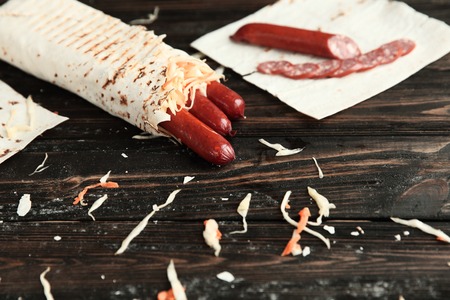 Shawarma with sausage on a wooden table.photo with copy space