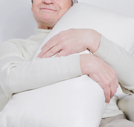elderly man with a comfortable pillow.isolated on whiteの写真素材