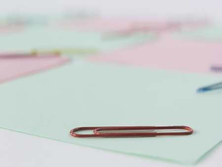 close up.red paper clip on blurred background .photo with copy spaceの写真素材