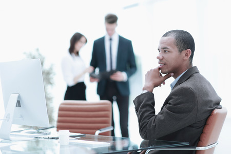 confident young businessman on blurred background office