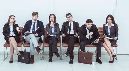 business team prepares for the beginning of the presentation sitting in the lobby of the conference hallの写真素材