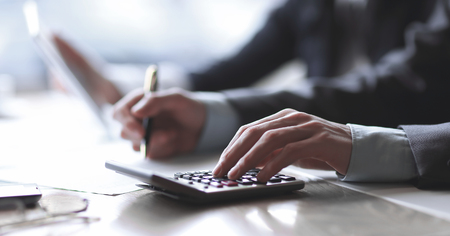 close up. a businessman uses a calculator for calculating profitsの写真素材