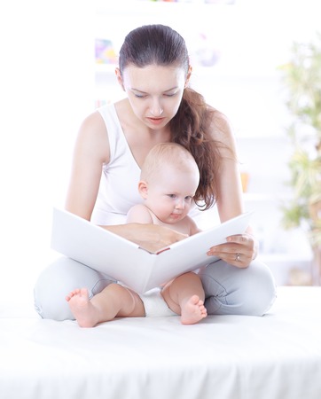 charming mom reading a book to her baby