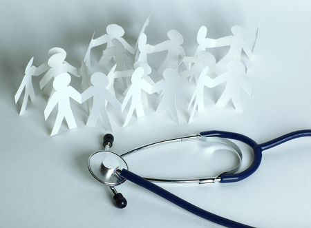 stethoscope and paper men on the table.the concept of family medicineの写真素材