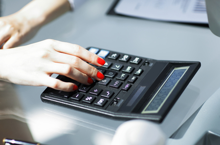 .closeup.business woman using a calculator at the workplace.の写真素材
