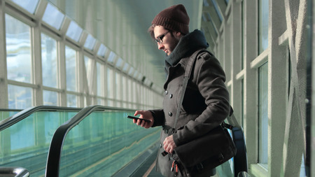 young man reading an SMS while standing in the subway