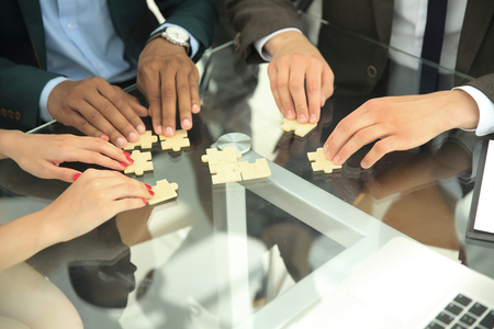 close up .multinational business team assembling puzzle.の写真素材