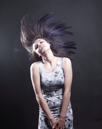 Portrait of young attractive brunette woman with black backdropの写真素材