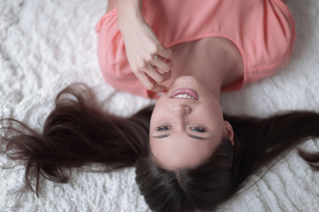 top view.young woman lying on white carpet in living roomの写真素材