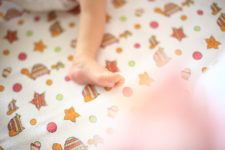 leg sleeping baby lying on baby blanket.の写真素材