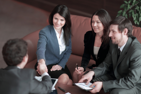 close up.business woman shaking hands with business partner sitting at work Deskの写真素材