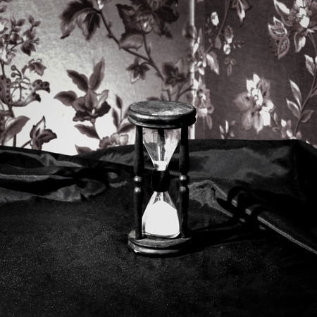 closeup.hourglass with white sand on a wooden table