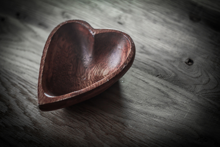closeup.wooden salad bowl in the shape of a heartの写真素材