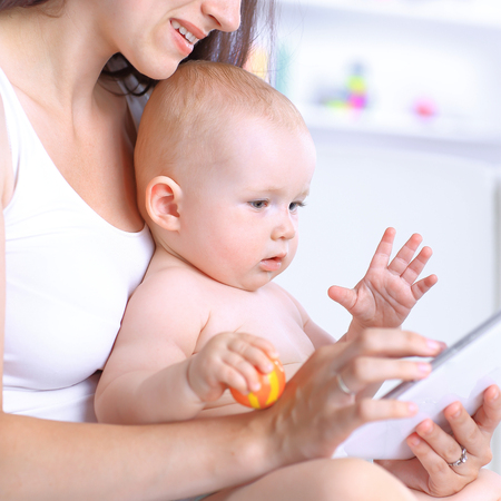 mom and baby are looking at the digital tablet screen