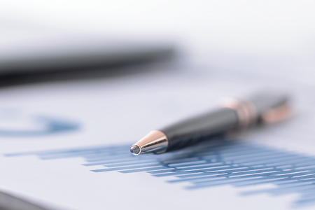 blurred image pen on a sheet with a financial chartの写真素材