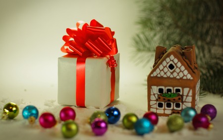 box with Christmas present and gingerbread house on a festive baの写真素材