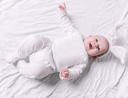 cute smiling baby lying on the bed.