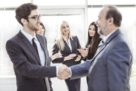 welcome and handshake of business partners on the background of applauding employeesの写真素材