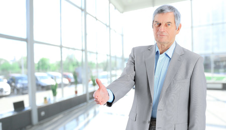 confident senior businessman holding out hand for a handshakeの写真素材