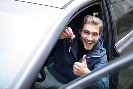 happy young man in his new car.の写真素材