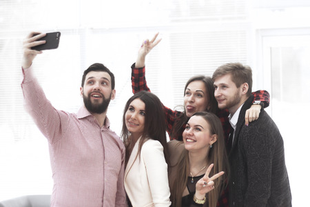 creative business group takes selfies in a modern office
