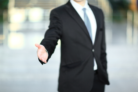 handsome businessman holding out hand for a handshake.の写真素材