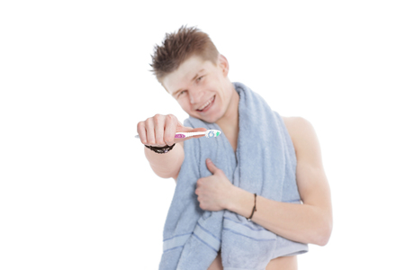 young man with towel and toothbrush.isolated on whiteの写真素材