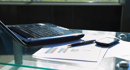 laptop, mobile phone and pen on desktopの写真素材