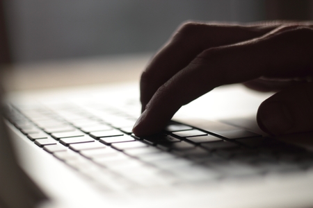 close up. blurred image of male typing on laptop keyboardの写真素材