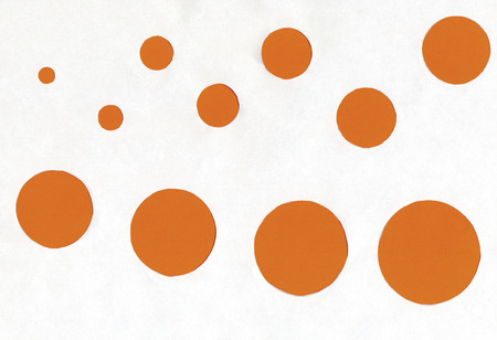 small and large orange circles on a white background.の写真素材