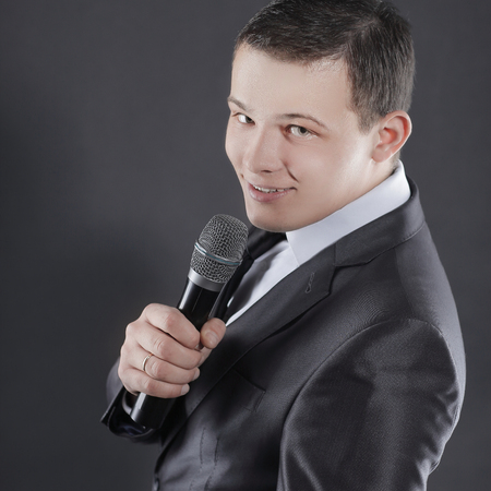young successful businessman with microphone.isolated on black