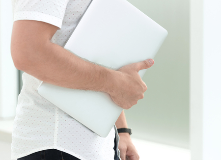 close up. business woman with laptop standing near office windowの写真素材