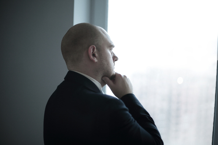 close up. thoughtful businessman looking in the office window