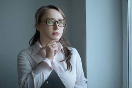 attentive business woman looking out the window of the office.の写真素材