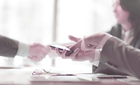 close up.a businessman uses a smartphone during a business meeting.の写真素材