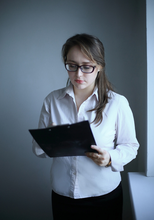 business woman reading a business document.isolated on greyの写真素材