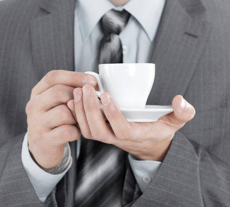 closeup.businessman with a Cup of coffee, isolated on white backgroundの写真素材