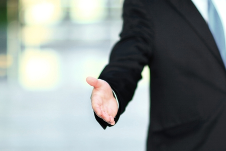 handsome businessman holding out hand for a handshake.の写真素材