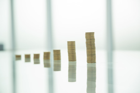 stacks of gold coins on a glass table.の写真素材