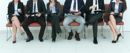 business team with clipboards sitting in a rowの写真素材