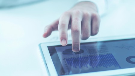 businessman using digital tablet, working with the financial schedule at the Deskの写真素材