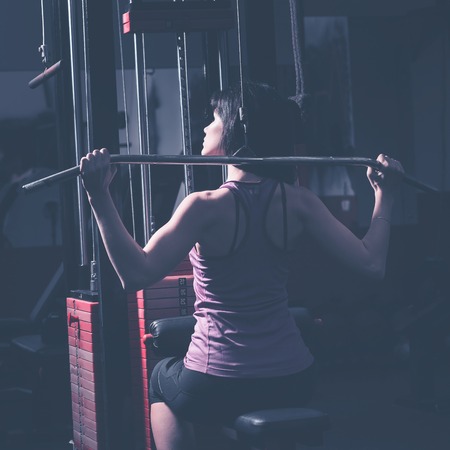 Modern business woman next to a fitness machine at a fitness lessonの写真素材