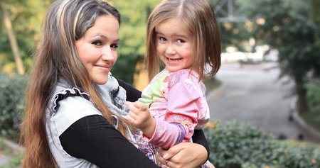 portrait of mother and little daughter in autumn city Park