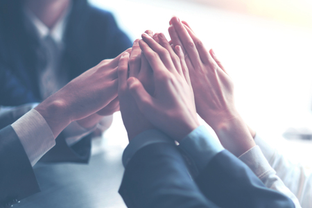 Image of business people hands top of each other