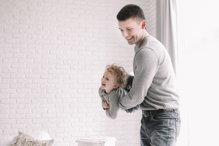 father playing with little daughter in a spacious living roomの写真素材