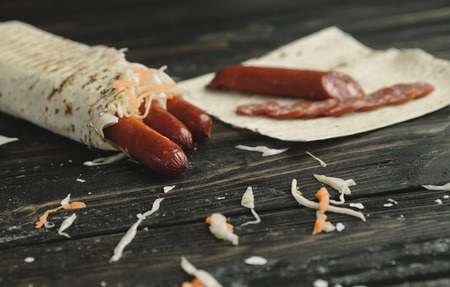 smoked sausage in pita bread on a wooden tableの写真素材