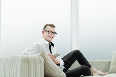 business man sitting on the couch in his living roomの写真素材